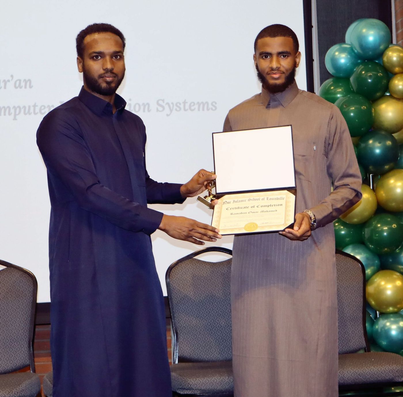 Br. Ramadan Omar, right, receiving his certificate of completion on stage